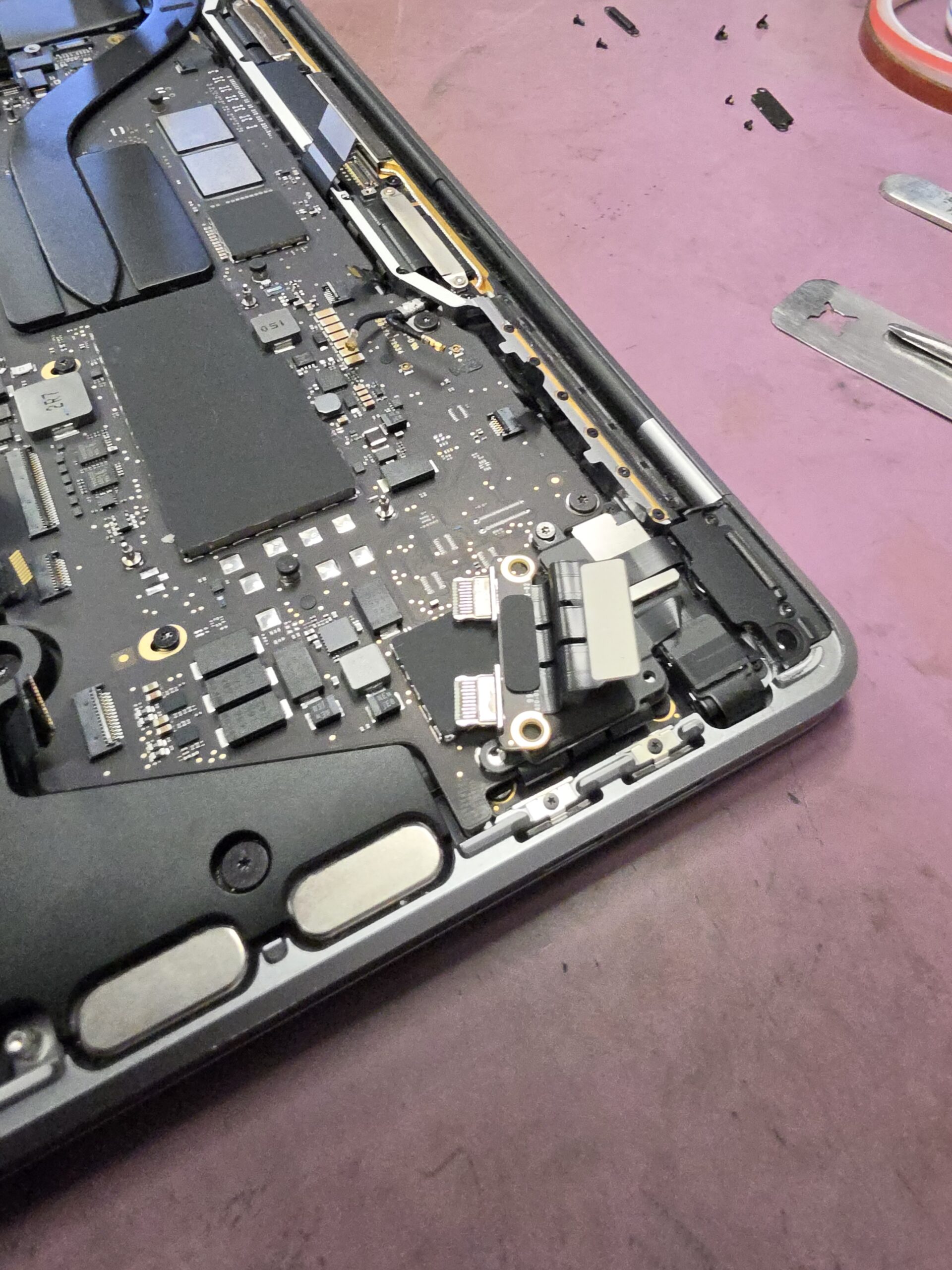 MacBook Pro A2338 USB-C charging port assembly during replacement at iPhoneBits