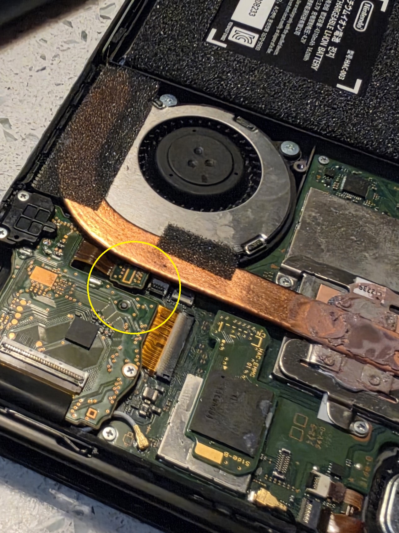 Nintendo Switch loose touchscreen cable connection, with the affected area circled in yellow