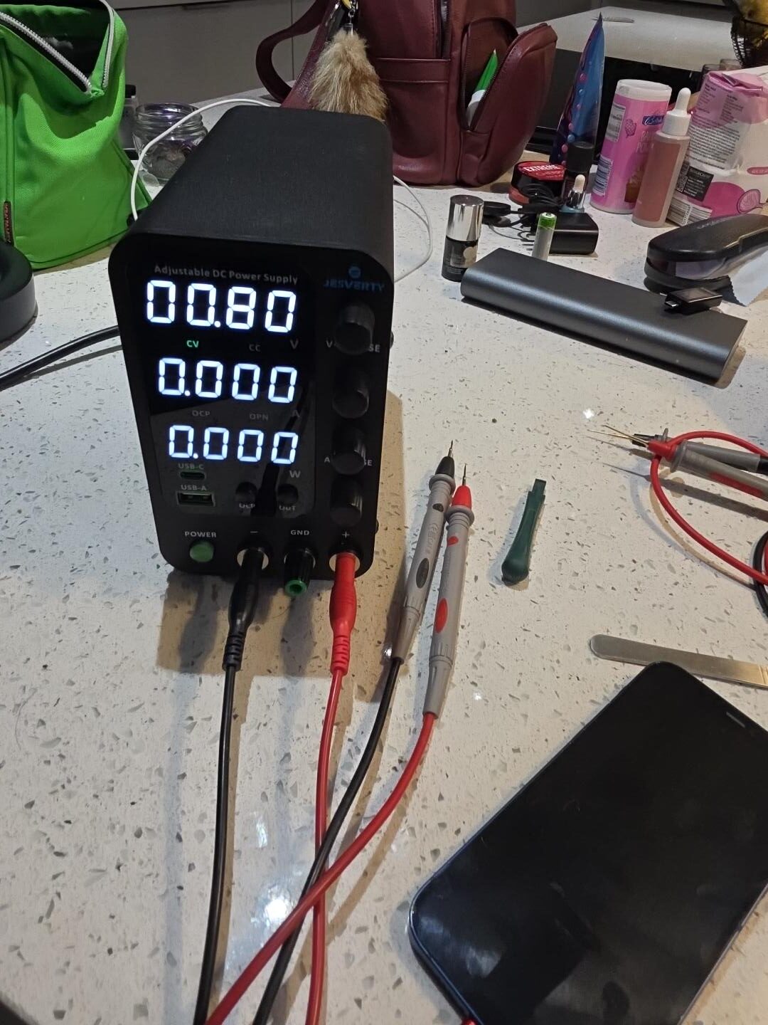 Bench power supply used for controlled low-voltage injection during MacBook short-circuit diagnosis